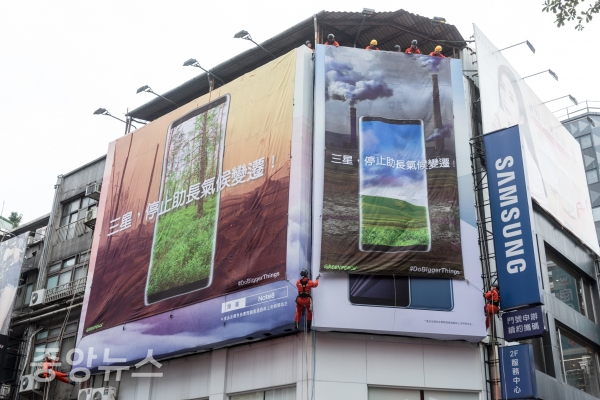 그린피스 활동가들이 지난달 30일 대만 타이베이 삼성전자 판매장에서 대형 현수막을 펼치며 삼성전자에 기후변화를 앞당기는 화석연료 대신 재생가능에너지 사용 약속을 촉구하는 메시지를 전하고 있다.[사진=그린피스]