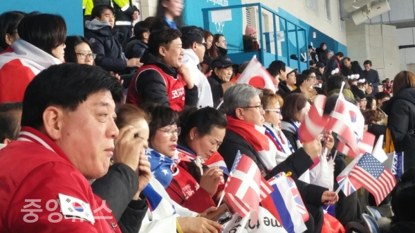 강릉 컬링경기장에서 코리안서포터즈 회원들이 출전 8개국의 국기를 흔들며 열띤 응원하는 모습. 신수민 기자.