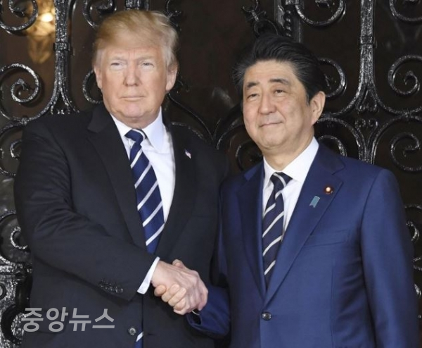 아베 일본 총리와 도널드 트럼프 미국 대통령이 17일(현지시간) 트럼프 대통령의 별장인 마러라고 리조트에서 같은 무늬 넥타이를 착용한 채 악수하고 있다. (사진=연합뉴스 제공)