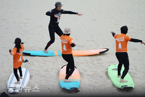 해변에서 패들과 일어서는 연습을 하고 있는 장면 (사진=한국관광공사 제공)