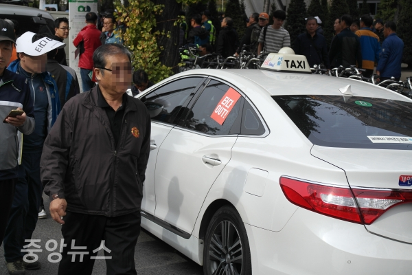 23일 오후 서울 여의도 국회 앞 의사당대로에서 모빌리티 서비스 ‘타다’를 규탄하는 집회 ‘택시대동제’린 가운데 한 택시 기사가 갓길에 '타다 OUT' 스티커가 붙은 택시를 주차시켰다. (사진=우정호 기자)