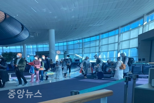 중국 단체 여행객들이 비닐 우비를 착용한 채 인천공항을 통해 입국하고 있다 (사진=신현지 기자)