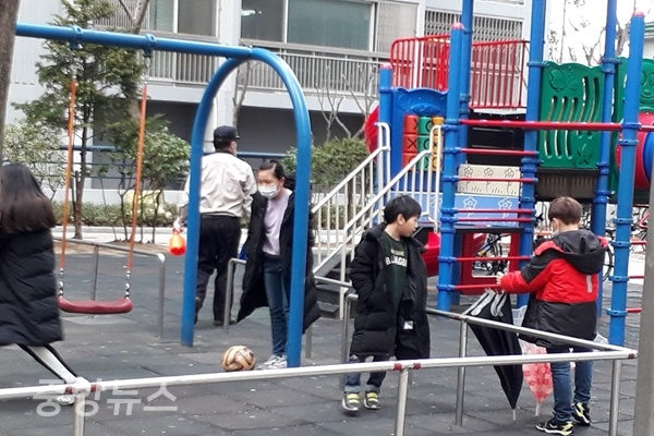 학원들의 휴원 조치에 아파트 놀이터를 차지한 어린이들과 한 편에는 경비원이 수시로 놀이기구를 방역하는 모습 (사진=신현지 기자)