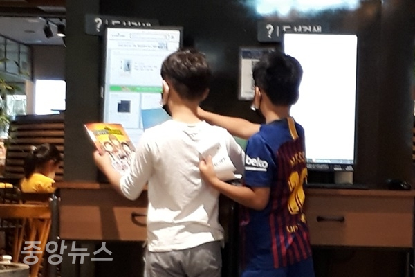 18일 대형서점에서 비대면을 통해 도서목록을 확인하는 어린이들 (사진=신현지 기자)