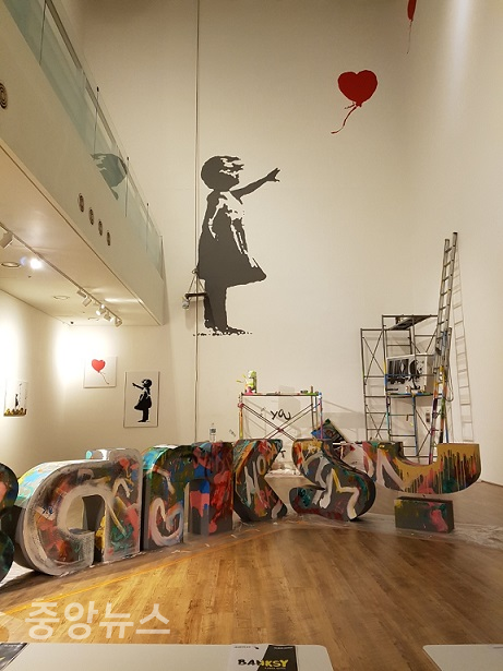 국내에서도 전시회를 개최한 적이 있는 영국의 얼굴 없는 아티스트 '뱅크시'가 자신의 가장 유명한 작품 여러 개의 상표권을 박탈당했다.(사진=국내에서 공개한 뱅크시 작품,풍선날리는 소녀)