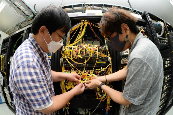ETRI 연구진이 국가연구개발망(KOREN)에 데이터 중심 네트워킹 기술을 실증하고 있 는 모습 (왼쪽에서부터 김호건 연구원, 신용윤 연구원) (제공=ETRI)