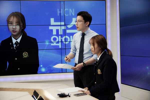 HCN 담당직원이 HCN의 지역채널 제작 스튜디오에서 지역 학교 방송반 학생의 뉴스 체험을 지원하는 모습 (제공=HCN)