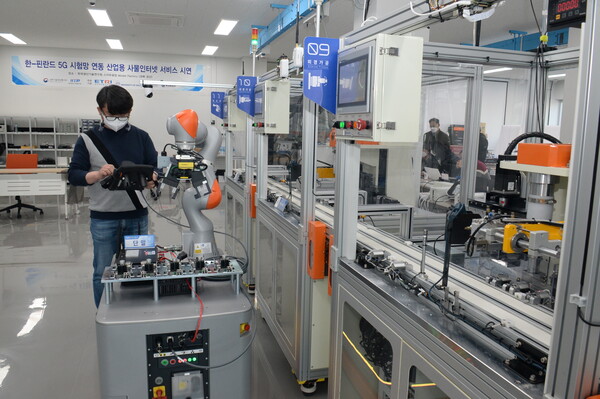 ETRI 연구진이 스마트공장 내 이동형 로봇을 국산 5G 기술을 이용해 실시간으로 제어하는 모습 (제공=ETRI)