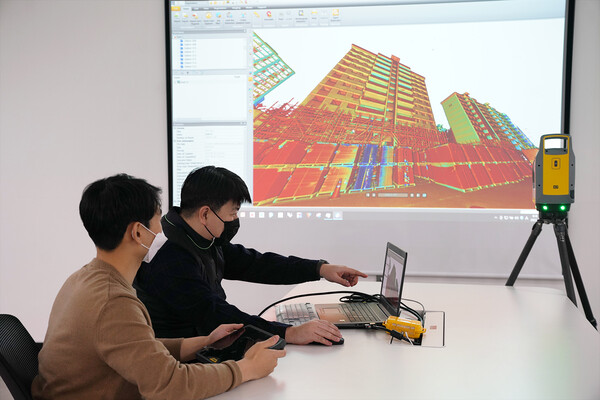 롯데건설 관계자가 3D 스캐너를 활용한 기존 아파트 모델링 데이터를 확인하고 있다. (제공=롯데건설)