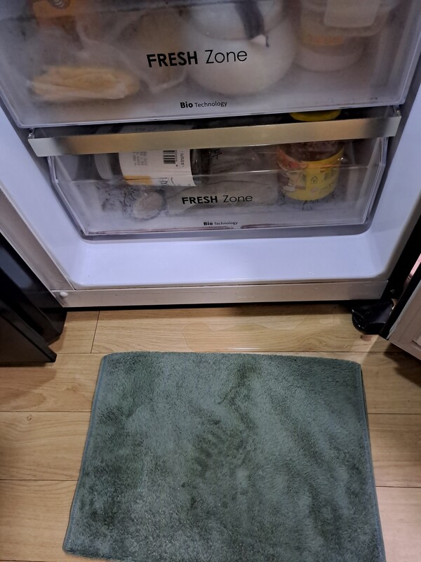냉장고 냉동실에서 물이 새어 바딱에 헝근하게 고여 있다.