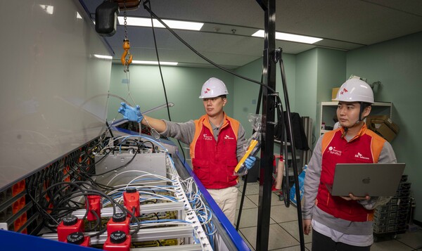 SKT 직원들이 인천사옥에 설치된 액침냉각 테스트 장비를 점검하는 모습 (제공=SK텔레콤)