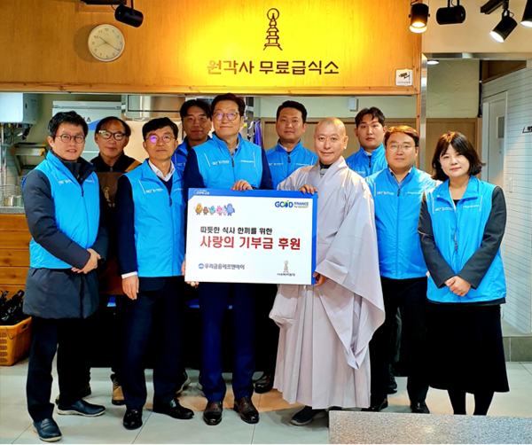 우리금융에프앤아이 김건호 대표이사(왼쪽에서 다섯번째), 전성찬 상무(왼쪽에서 세번째), 원각사 원경스님(왼쪽에서 일곱번째)이 기념촬영을 하고있는 모습.(사진=우리금융 제공)