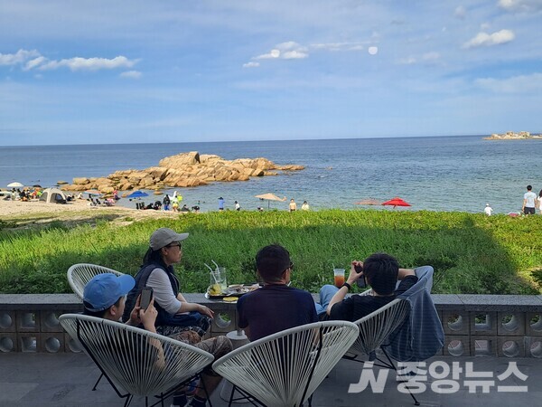   조용한 카페 테라스에서 바다를 바라다 보는 오션뷰가 사람들에게 안정감을 더해준다