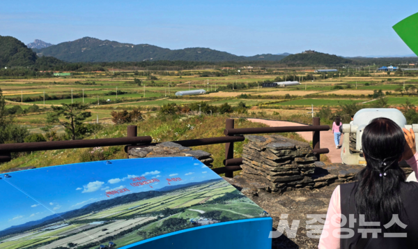 사진: 백마고지 전적지에서 탐방객들이 북측 고암산(김일성 고지),효성산을 망원경으로 관찰 하고있다(사진: 미술여행 류재림 편집위원 25.10.8일 갤럭시S24 울트라 촬영)