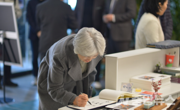 전시장을 찾은  관람객이 방명록에 이름을 적고 있다. 